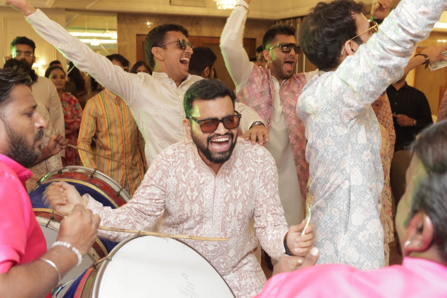 Guests dancing around a dhol player at a celebration